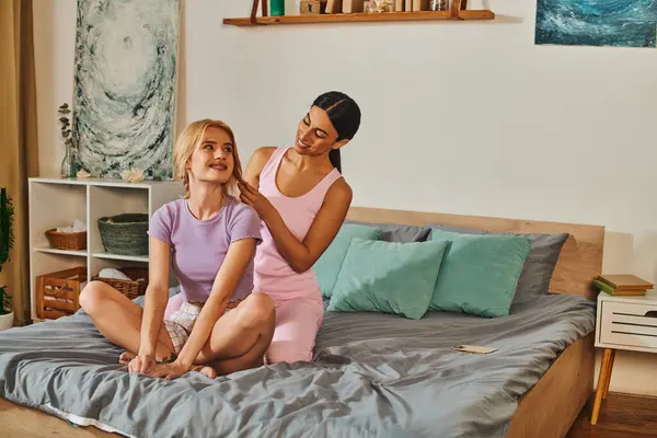 A joyful lesbian couple, of different races, embraces in their home, exuding love and intimacy — Stock Photo