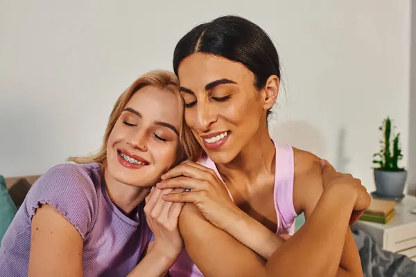 Um casal lésbico feliz abraça em sua casa acolhedora, desfrutando de tempo de qualidade juntos. — Fotografia de Stock