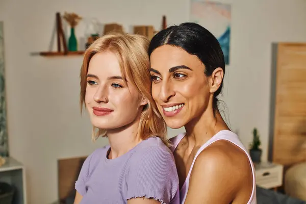 A happy lesbian couple embraces in their cozy home, radiating warmth and love. — Stock Photo