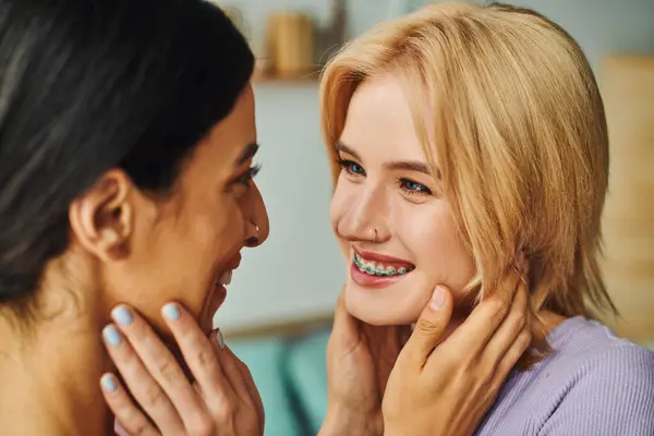 Two women are embracing each other, smiling and gazing into each other eyes. — Stock Photo