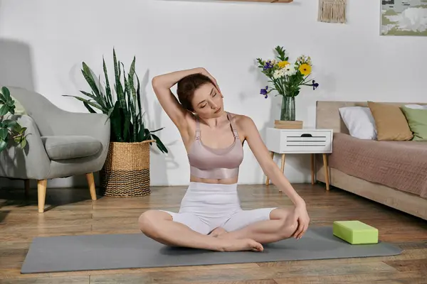 A beautiful Asian woman in a crop top practices yoga and meditation in a modern apartment, bathed in soft natural light. — Stock Photo