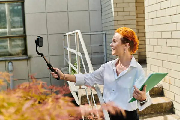 A teacher takes a selfie with a selfie stick on campus. — Stock Photo