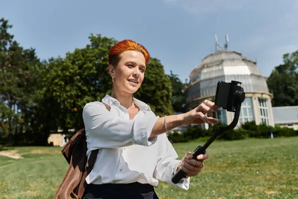Una giovane donna, probabilmente un'insegnante, si fa un selfie in un campus soleggiato. — Foto stock