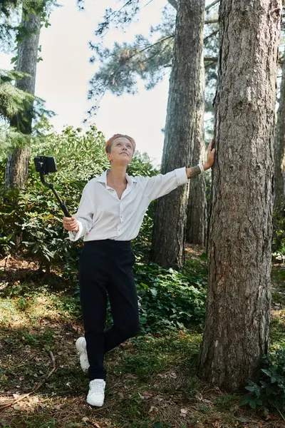 A teacher in a white shirt poses for a selfie in a forest. — Stock Photo