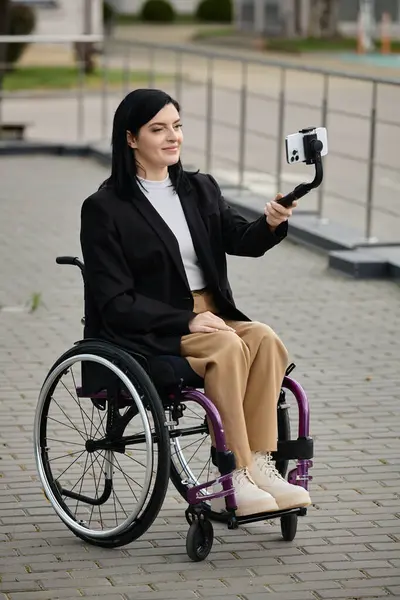 A woman smiles as she takes a selfie in a wheelchair. — Stock Photo
