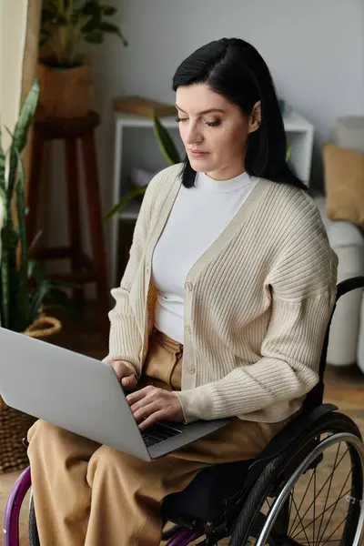 A woman in a wheelchair works on a laptop. — Stock Photo