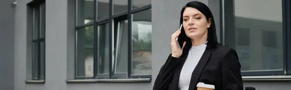 Женщина в инвалидной коляске разговаривает по телефону возле офисного здания. — стоковое фото
