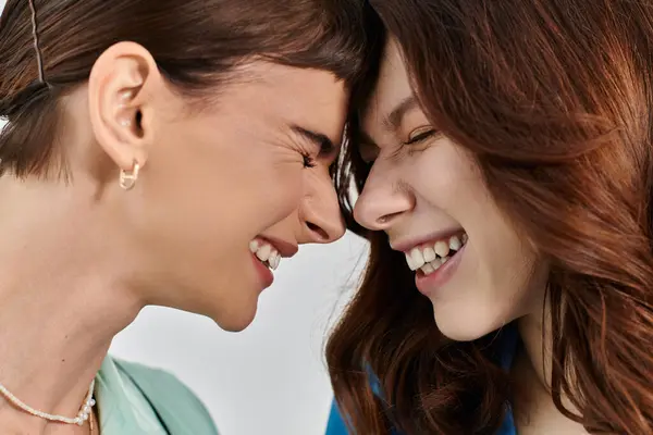 Two young women in pajamas share a close moment of laughter and intimacy in the morning. — Stock Photo