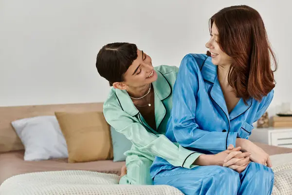 Una joven pareja lesbiana comparte un momento amoroso en pijama, su mañana llena de risas e intimidad. - foto de stock