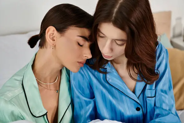 Молодая пара лесбиянок расслабляется в постели, надевает пижаму и демонстрирует свою любовь друг к другу. — стоковое фото