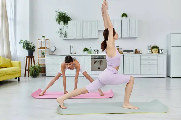 A young lesbian couple stretches and practices yoga together in their modern apartment. — Stock Photo