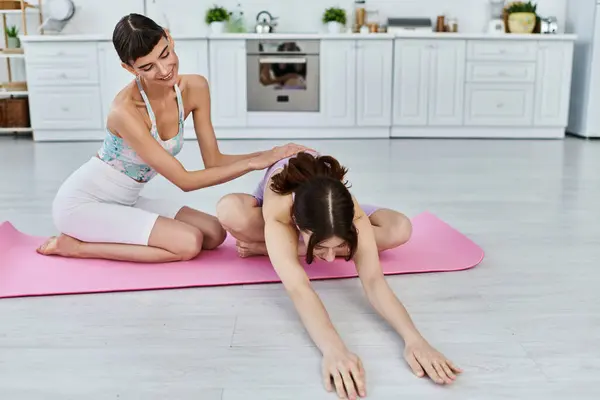 Two women practice yoga together in a modern apartment. — Stock Photo