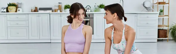 A young lesbian couple practices yoga together in a modern apartment, sharing a moment of quality time and mindfulness. — Stock Photo