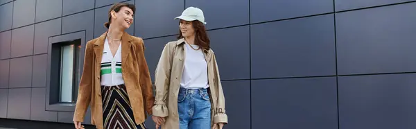 Two women in trendy outfits stroll together in an urban setting. — Stock Photo