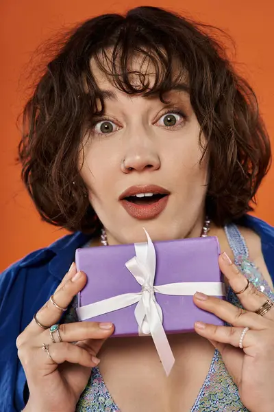 A woman in a colorful outfit stares in wonder at a gift. — Stock Photo