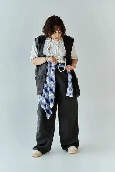 A woman adjusts a plaid scarf tied around her waist. — Stock Photo