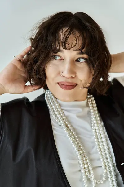 Woman with short, curly hair and pearl necklace gazes off-camera intensely — Stock Photo