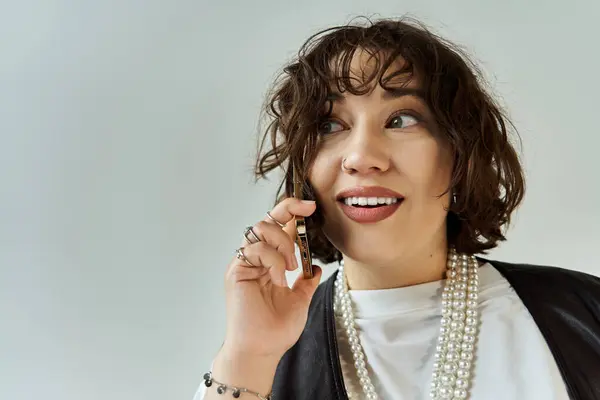 A woman with curly brown hair smiles as she talks on a phone. — Stock Photo