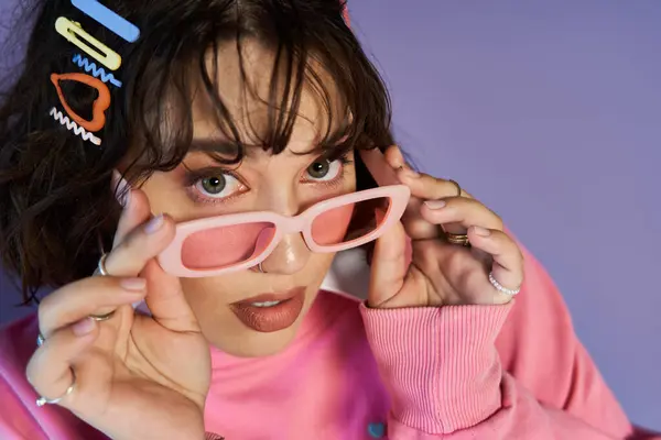 A young woman with pink sunglasses stares directly at the camera. — Stock Photo