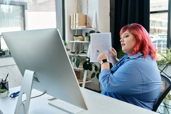 Женщина plus size показывает на документ, глядя на монитор компьютера. — стоковое фото