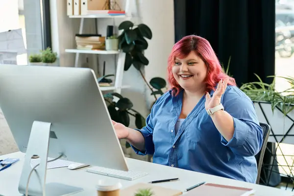 Una donna plus size con onde di capelli rosa sullo schermo del computer. — Foto stock
