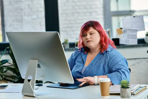 Une femme de taille plus avec les cheveux roses travaille à son ordinateur. — Photo de stock