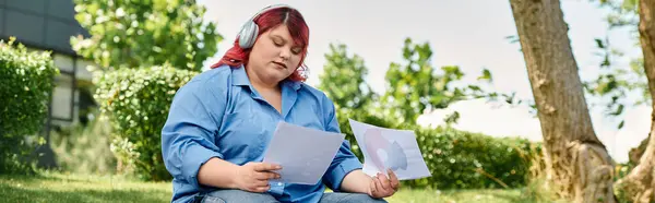 A plus size woman in colorful attire sits amidst lush greenery, enjoying a moment of peace and contemplation. — Stock Photo