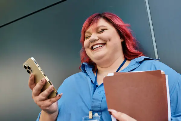 Uma mulher plus size com cabelo rosa brilhante ri enquanto olha para o telefone. — Fotografia de Stock