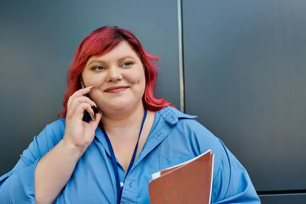 Женщина plus size с розовыми волосами улыбается во время разговора по телефону. — стоковое фото