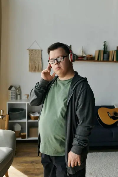 Um jovem com síndrome de Down desfruta de suas músicas favoritas enquanto relaxa em casa. — Fotografia de Stock