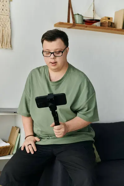 A man with Down syndrome records himself enjoying a creative moment at home. — Stock Photo