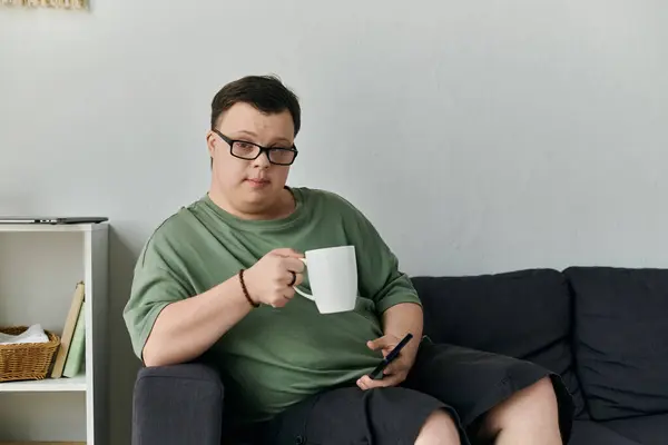 Enjoying a warm beverage while engaged with his phone. — Stock Photo
