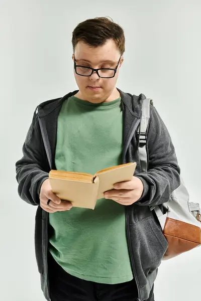 Enjoying a quiet moment, a young man with Down syndrome reads intently at home. — Stock Photo