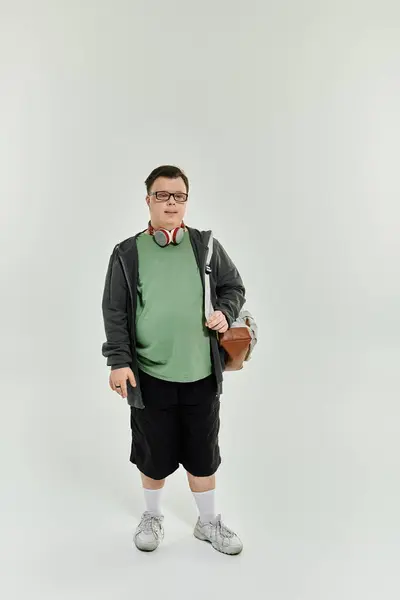 A young man with Down syndrome stands confidently at home, ready for an adventure. — Stock Photo