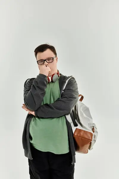 A young man with Down syndrome stands in contemplation, showcasing his unique style and outlook. — Stock Photo