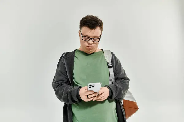 A man with Down syndrome enjoys texting while standing at home. — Stock Photo