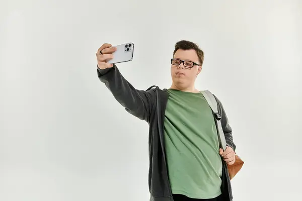 A young man with Down syndrome takes a selfie at home, smiling confidently. — Stock Photo