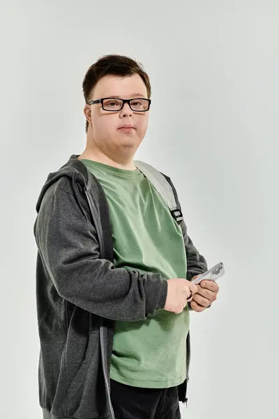 A young man with Down syndrome enjoys his time at home, holding a remote control. — Stock Photo