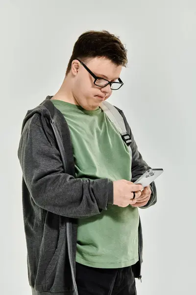 A young man with Down syndrome explores his smartphone while comfortably at home. — Stock Photo