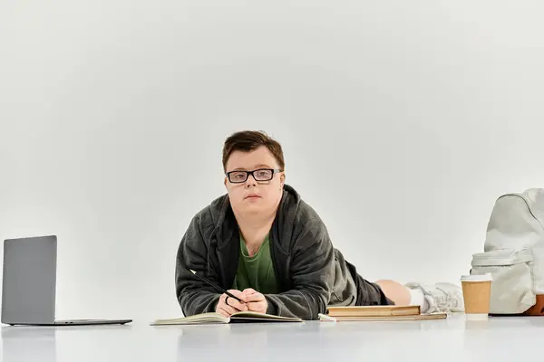 Молодой человек с синдромом Дауна учится в уютной домашней обстановке. — стоковое фото