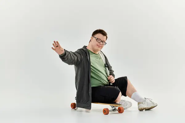 Ein fröhlicher junger Mann mit Down-Syndrom fährt Skateboard und lächelt herzlich. — Stockfoto