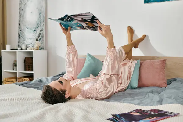 Stylish drag queen leisurely reading magazines in a cozy bedroom setting. — Stock Photo