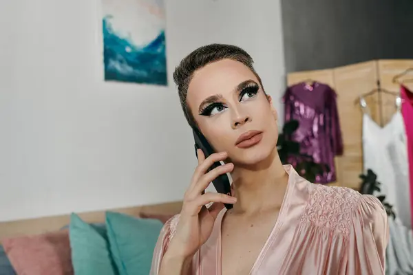 An attractive young drag queen poses thoughtfully on the phone in a stylish interior. — Stock Photo
