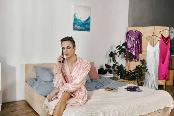 Radiant drag queen chats on the phone, surrounded by vibrant outfits and decor. — Stock Photo