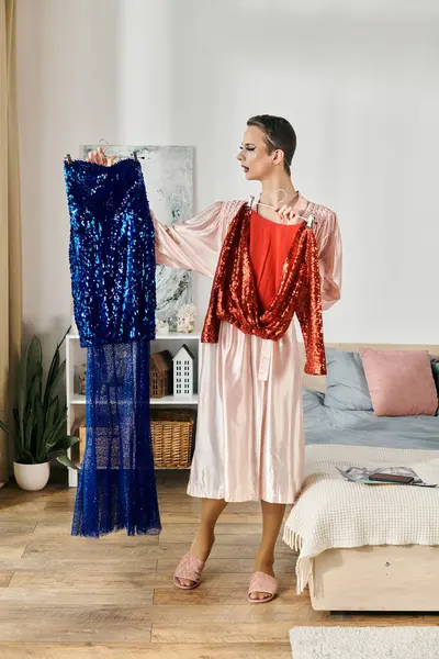 An attractive young drag queen selects between two glamorous outfits. — Stock Photo