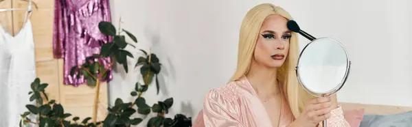 Una atractiva drag queen joven aplica maquillaje con estilo en un entorno de moda. - foto de stock