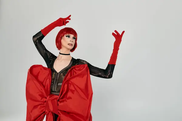 A dazzling drag queen showcases an eye catching red ensemble with grace and confidence. — Stock Photo