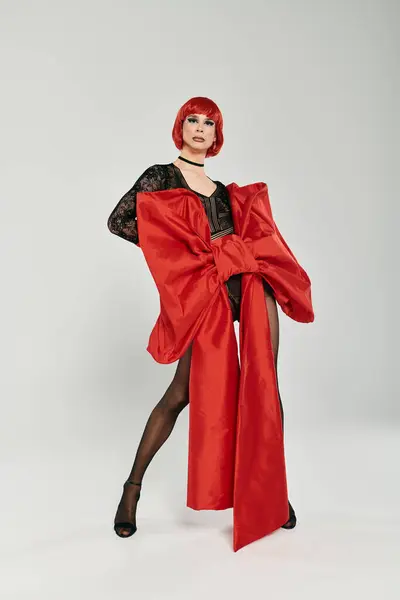 A stunning young drag queen poses confidently in a bold red ensemble. — Stock Photo