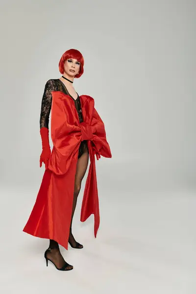 A stunning drag queen displays an eye catching red outfit with confidence. — Stock Photo