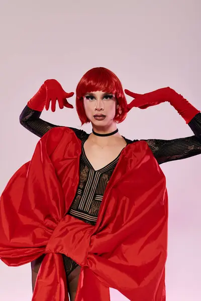 An attractive drag queen captivates with a striking red ensemble and bold pose. — Stock Photo